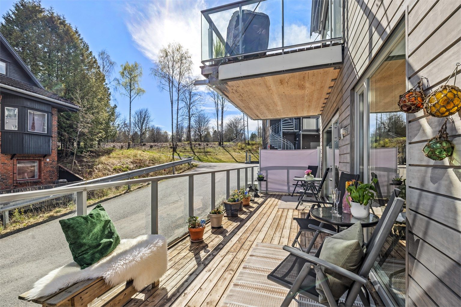 Terrassen strekker seg langs leilighetens fasade og gir rikelig med uteplass.