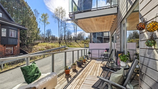 Terrassen strekker seg langs leilighetens fasade og gir rikelig med uteplass.