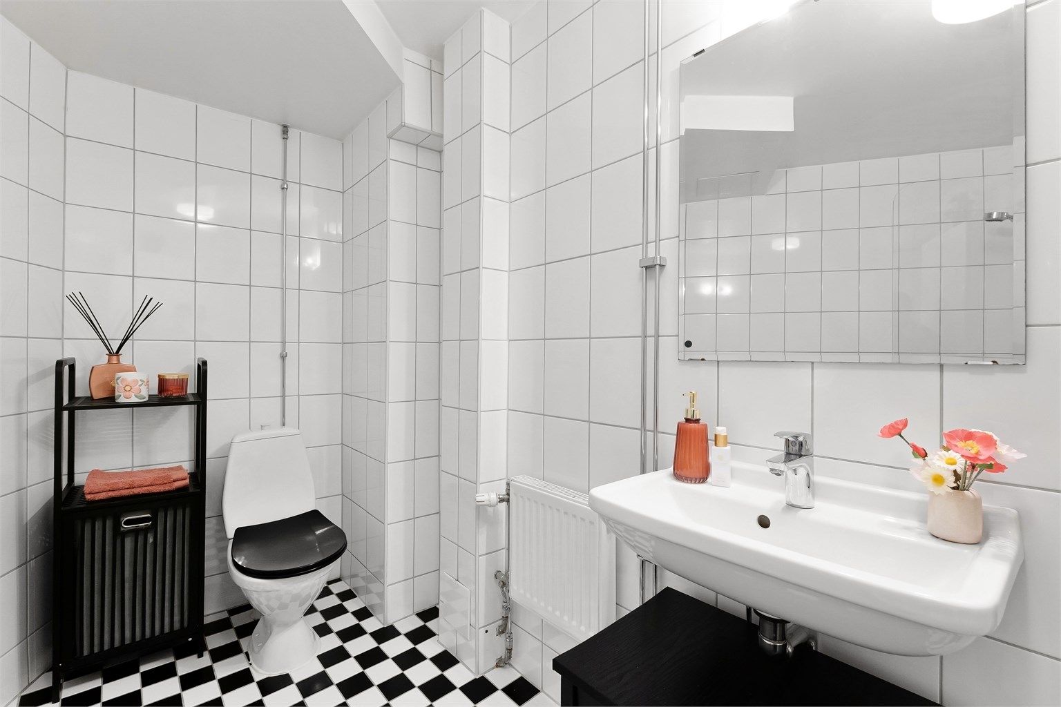 Klassiske, sjakkrutete fliser på gulvet gir badet karakter.