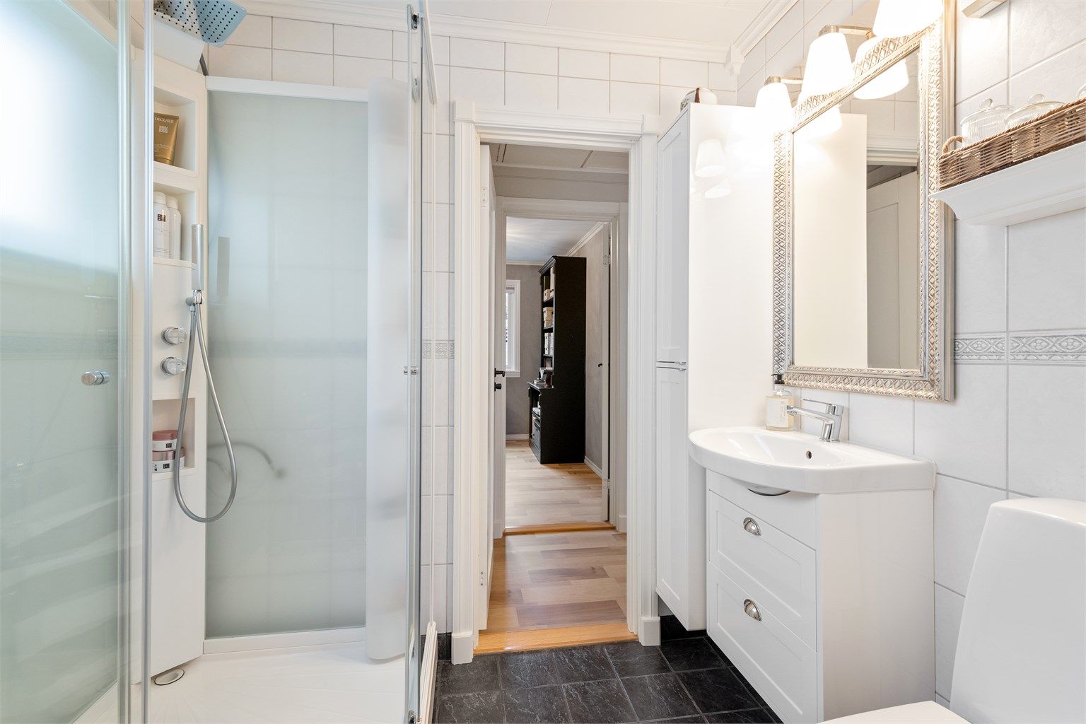 Badet er utstyrt med dusjkabinett, gulvstående toalett og har gulvvarme for ekstra komfort