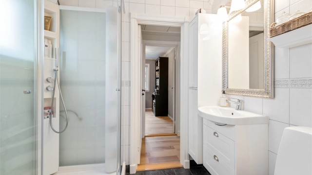 Badet er utstyrt med dusjkabinett, gulvstående toalett og har gulvvarme for ekstra komfort