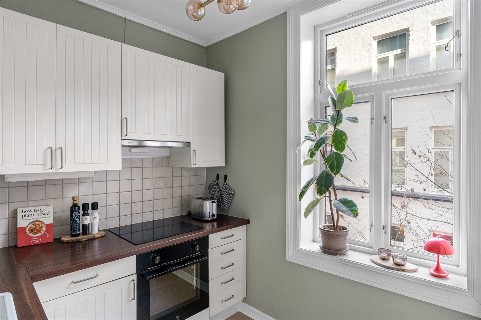 Trivelig kjøkken med vindu mot stille bakgård. 