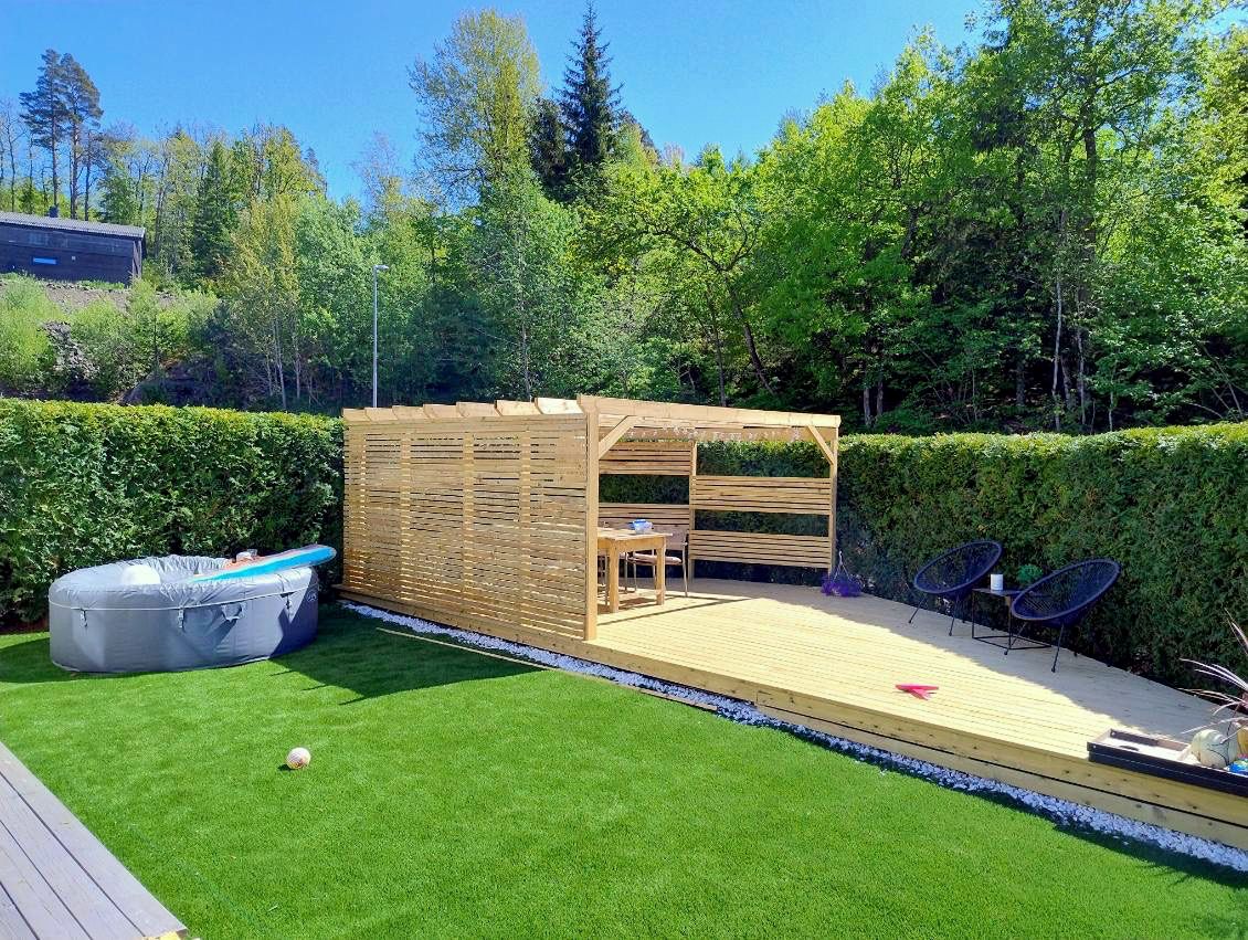 Uteplass med gressplen og pergola