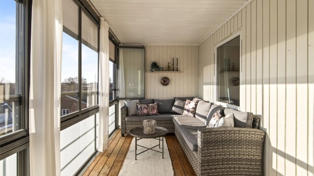 Balkongen måler cirka 15 kvm og fungerer ypperlig som en forlengelse av stuen store deler av året. Her får du også sen kveldssol samt pent utsyn over området (utvendig screens er montert på balkongen).