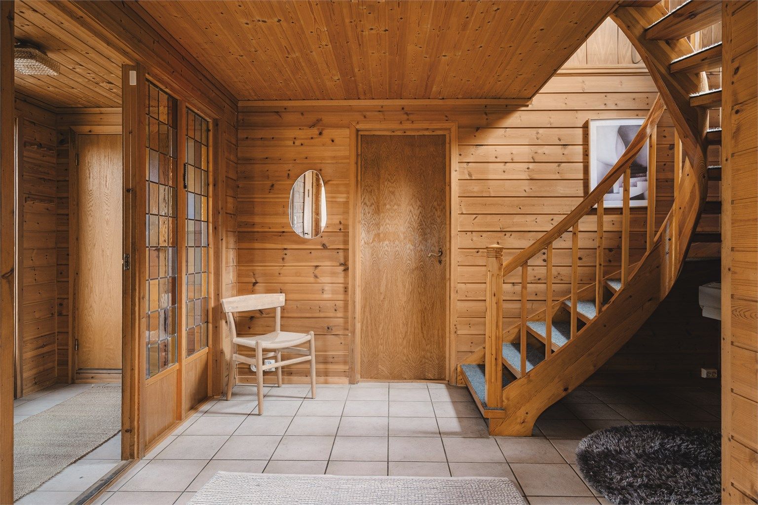 Romslig hall med flislagt gulv og gulvvarme.