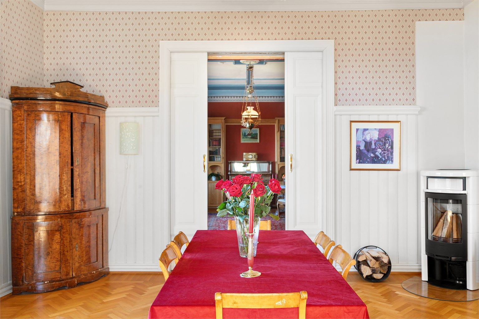 En vedfyrt peisovn gir varme, og profilerte skyvedører åpner inn til stuen