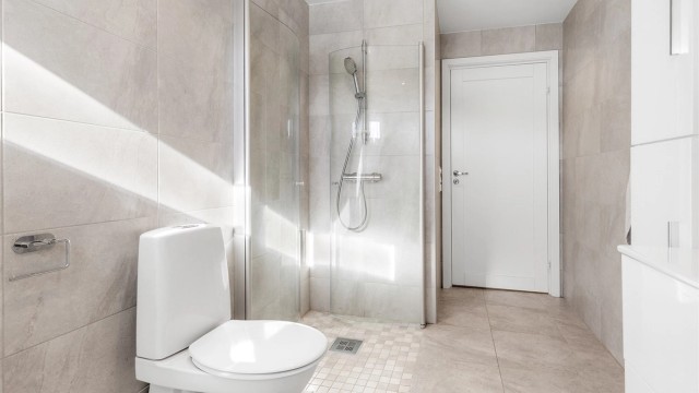 Badet har dusjhjørne med foldedører av glass