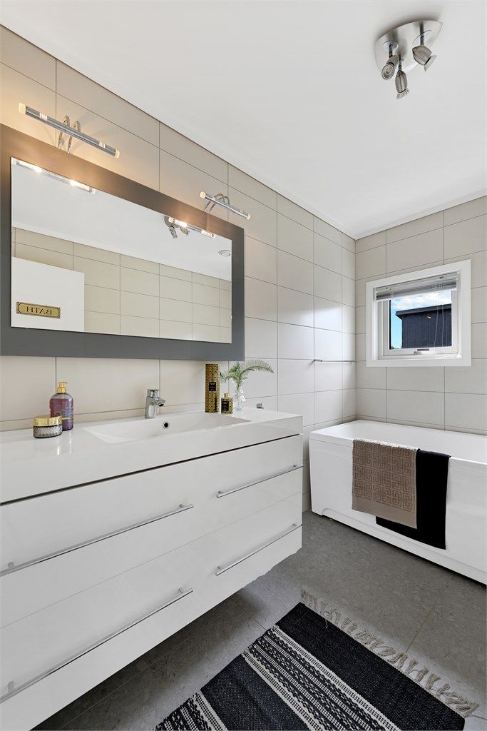 Badet i andre etasje er utstyrt med badekar og servant i innredning.
