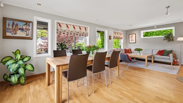 Stuen i første etasje har plass til både spisebord og sofagruppe, med gjennomgående parkett på gulvet.