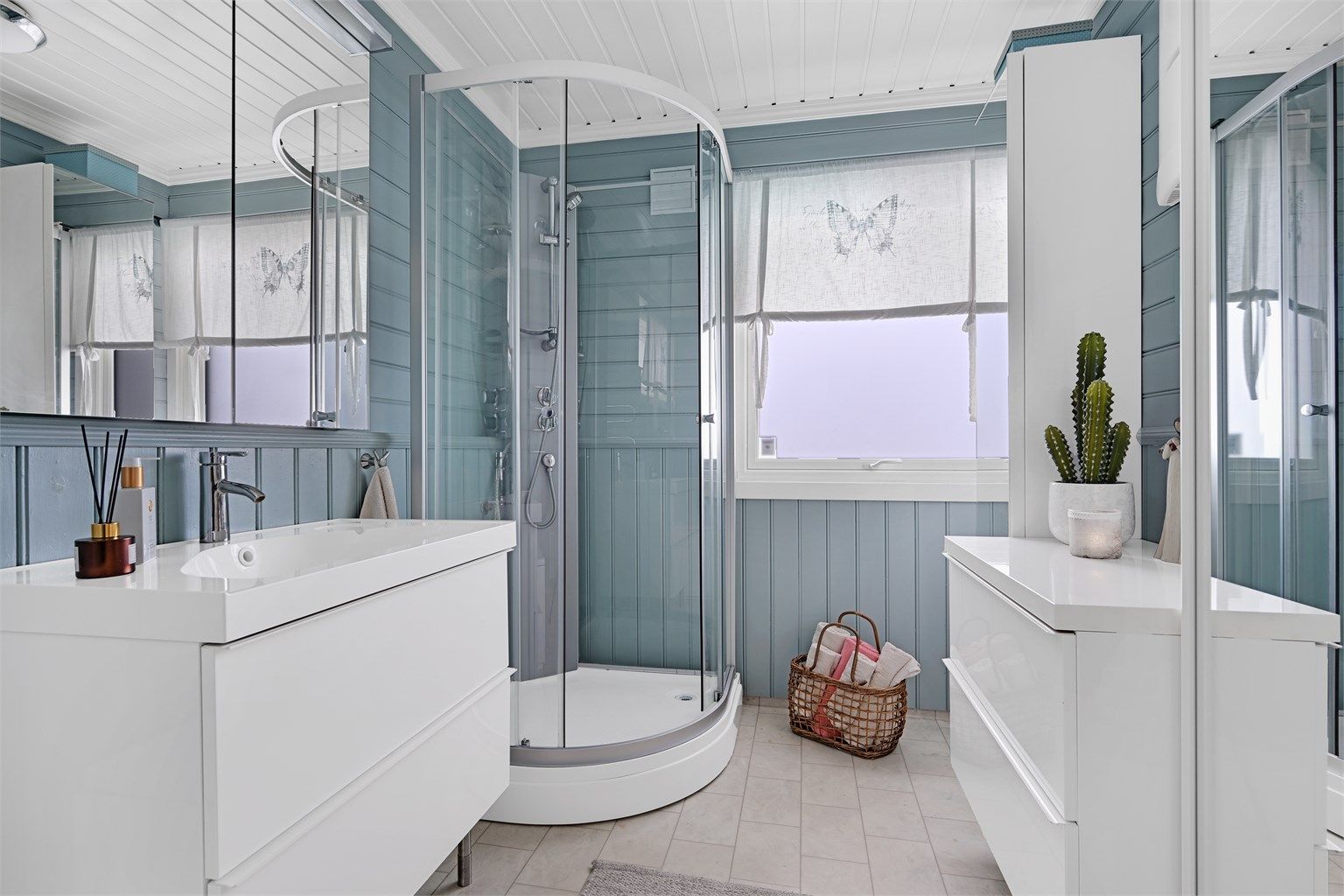 Badet er innredet med gulvmontert toalett, badekar, baderomsinnredning med nedfelt vask og dusjkabinett. 