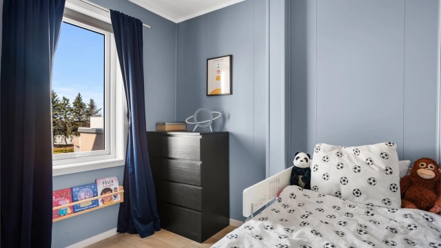 Boligens andre soverom har god plass til seng og oppbevaring, og passer utmerket som barnerom.