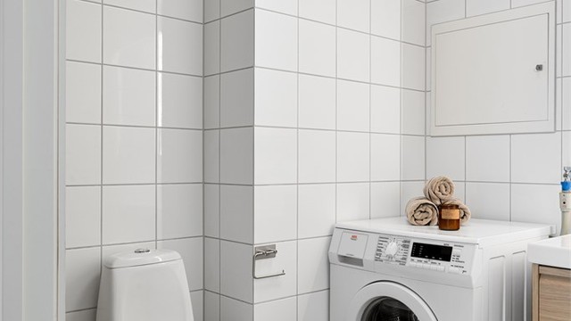 Badet er flislagt i en lys og behagelig fargepalett.