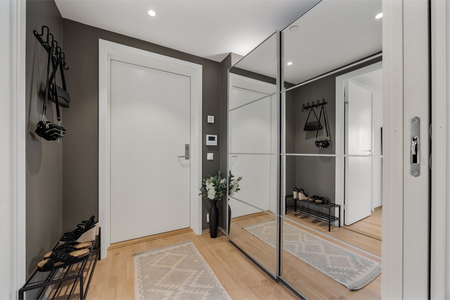 Innbydende inngangsparti med en smart garderobeløsning og vegghengte knagger til oppheng av yttertøyet.