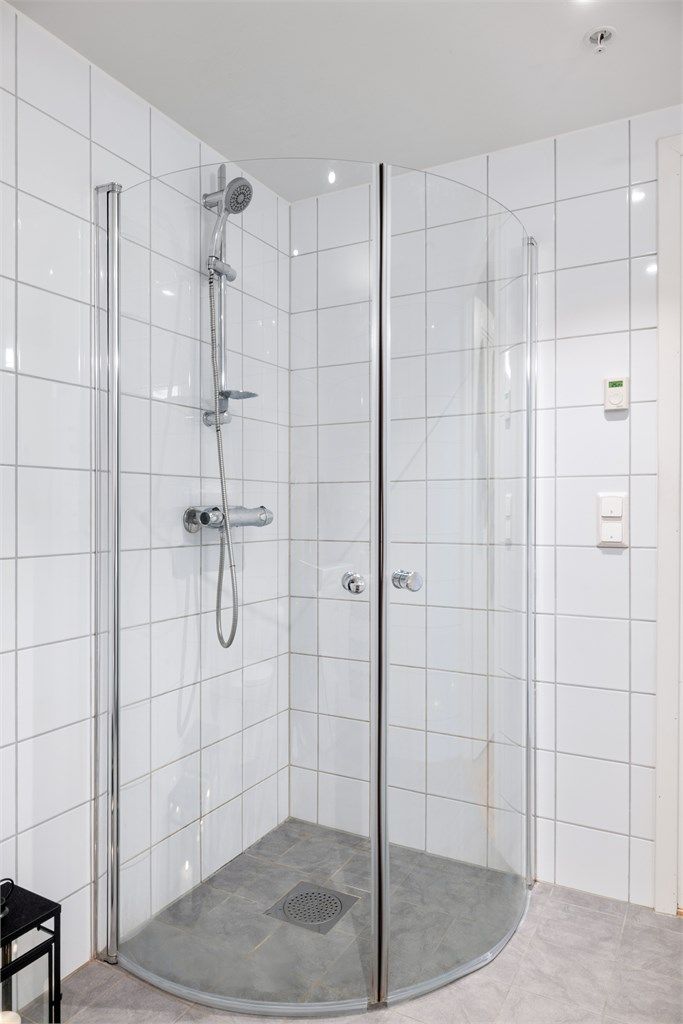 Innredet med vask, dusjnisje, vegghengt toalett og opplegg til vaskemaskin. 