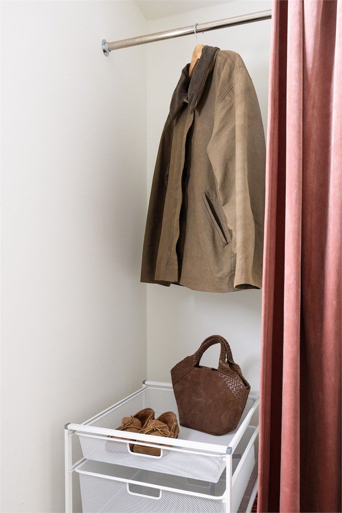 Smart garderobeløsning diskret gjemt bak et elegant forheng, som gir et ryddig og innbydende førsteinntrykk.