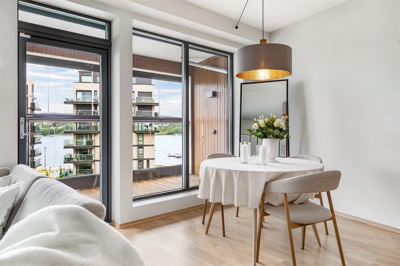 Vertikalstilte vinduer fyller stuen med mye naturlig lys og slipper også solstrålene inn fra utpå ettermiddagene, avhengig av årstiden.