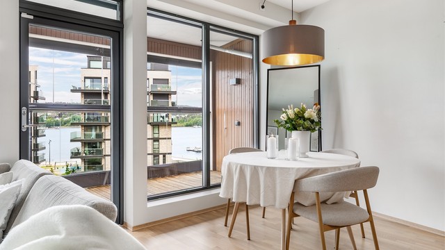 Vertikalstilte vinduer fyller stuen med mye naturlig lys og slipper også solstrålene inn fra utpå ettermiddagene, avhengig av årstiden.