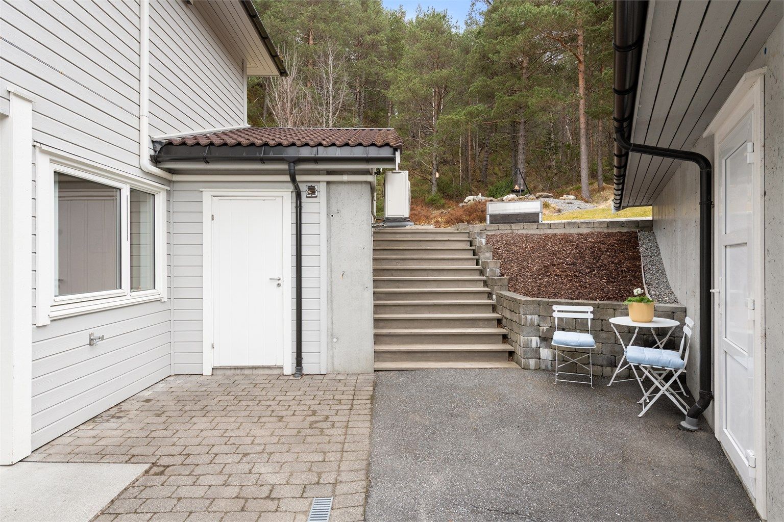 Utvendig trapp i tre ved sportsboden som leder opp til hagen og den store flotte markterrassen.