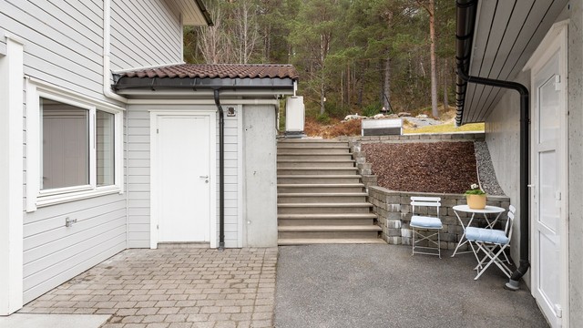 Utvendig trapp i tre ved sportsboden som leder opp til hagen og den store flotte markterrassen.