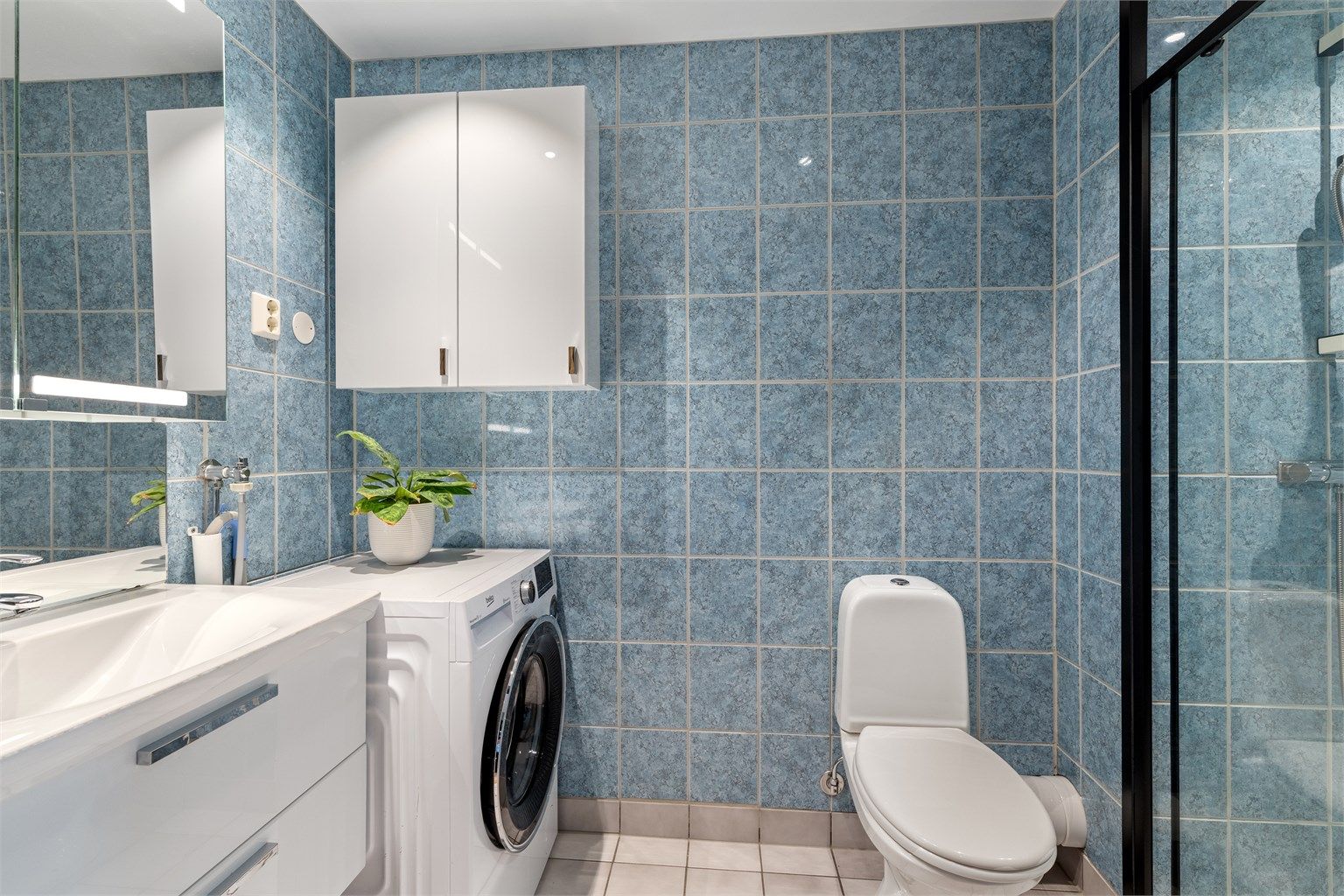 Badet er flislagt med varmekabler i gulvet for lun varme i rommet. Oppgradert med moderne baderomsmøbler og stilig dusjvegg