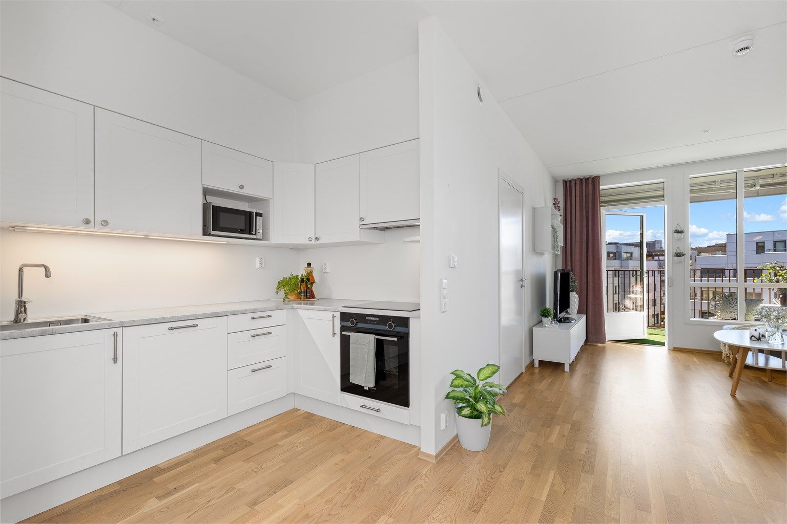 En gjennomgående og arealeffektiv 3-roms leilighet med åpen stue- og kjøkkenløsning som skaper en sosial og luftig atmosfære.