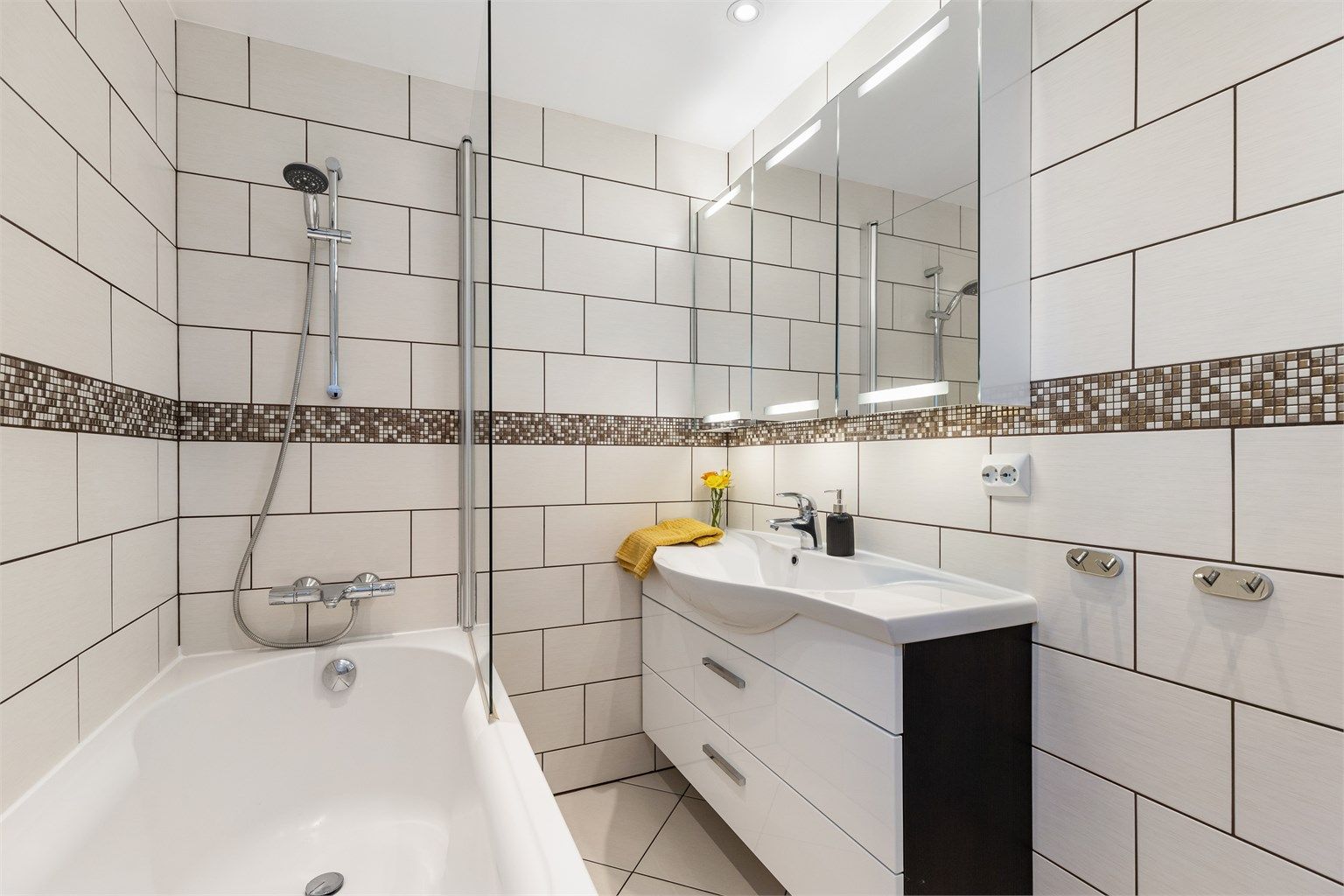 Baderomsinnredning med servant og speilskap med belysning. Vannrør av typen rør-i-rør.