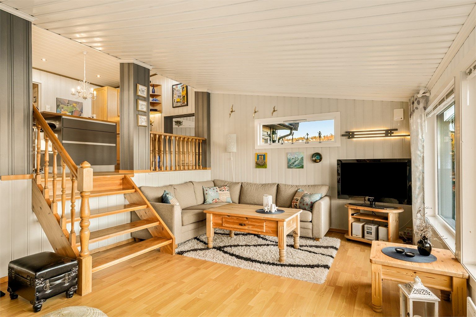 Stuen er et lyst og åpent rom med flere nivåer som skaper en naturlig inndeling.