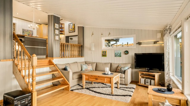 Stuen er et lyst og åpent rom med flere nivåer som skaper en naturlig inndeling.