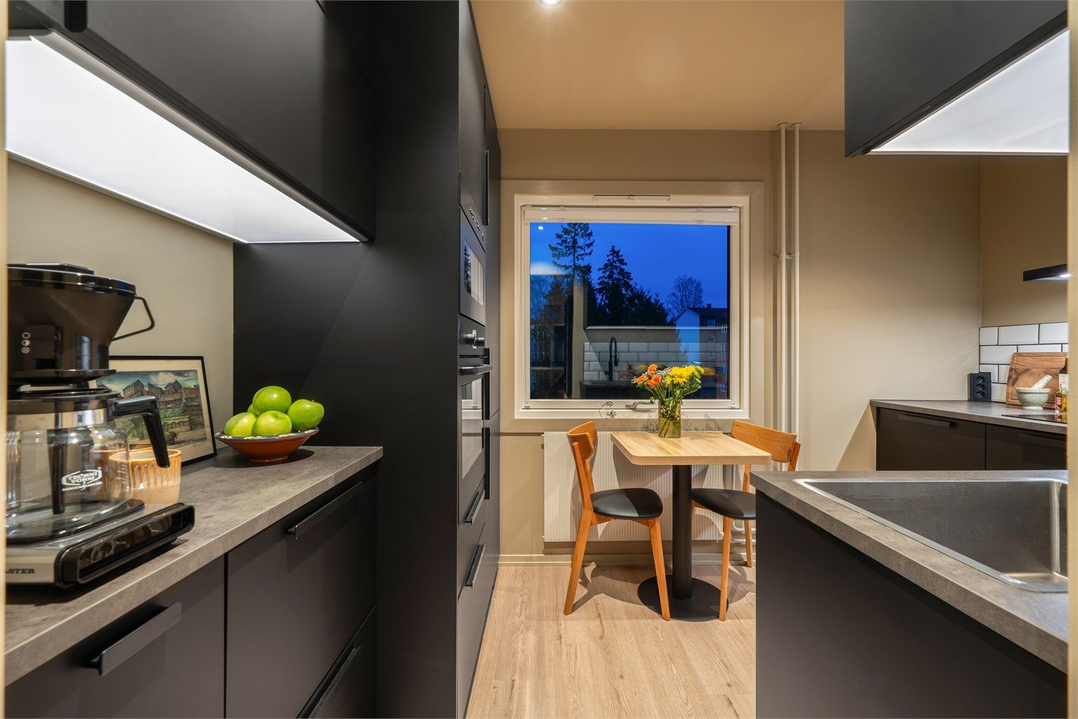 God arbeidsbelysning med downlights i taket og lyslist under overskapene.