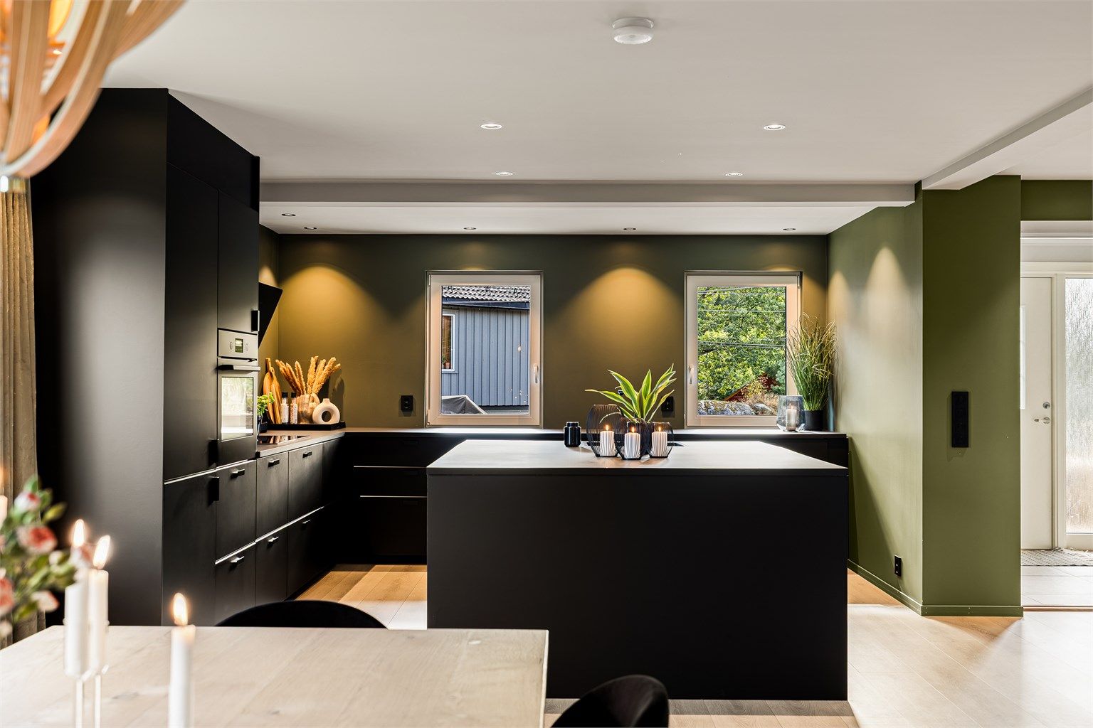 Kjøkkenet fra IKEA er i dempet sort med mye innredning og en kjøkkenøy som innbyr til sosialt samvær.