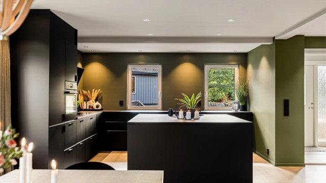 Kjøkkenet fra IKEA er i dempet sort med mye innredning og en kjøkkenøy som innbyr til sosialt samvær.