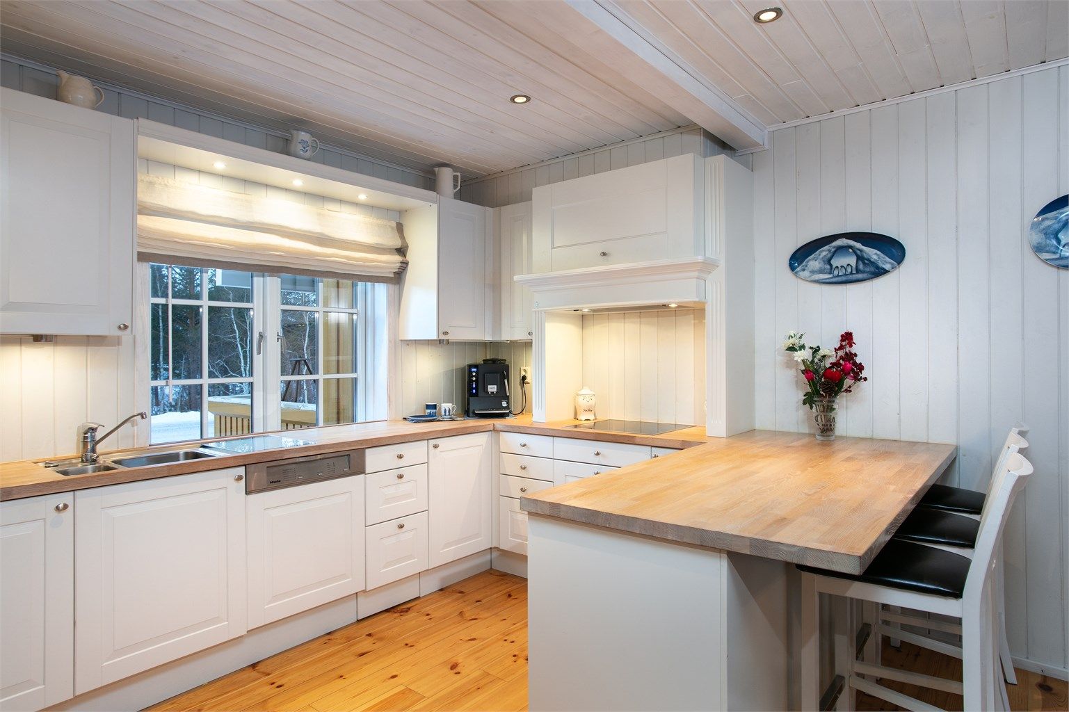 Kjøkkelhalvøy med spiseplasser mot stue/spisestue