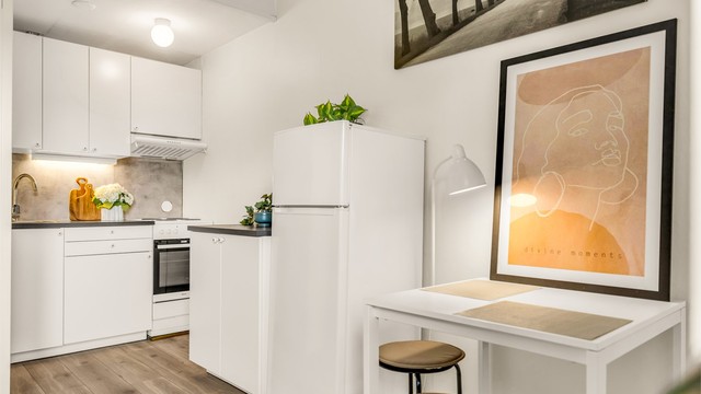 Kjøkken med moderne innredning fra 2020 med glatte fronter, benkeplate av laminat og nedfelt kjøkkenvask med armatur. Det er montert benkeskapsbelysning og stikkontakter under kjøkkenbenken.
