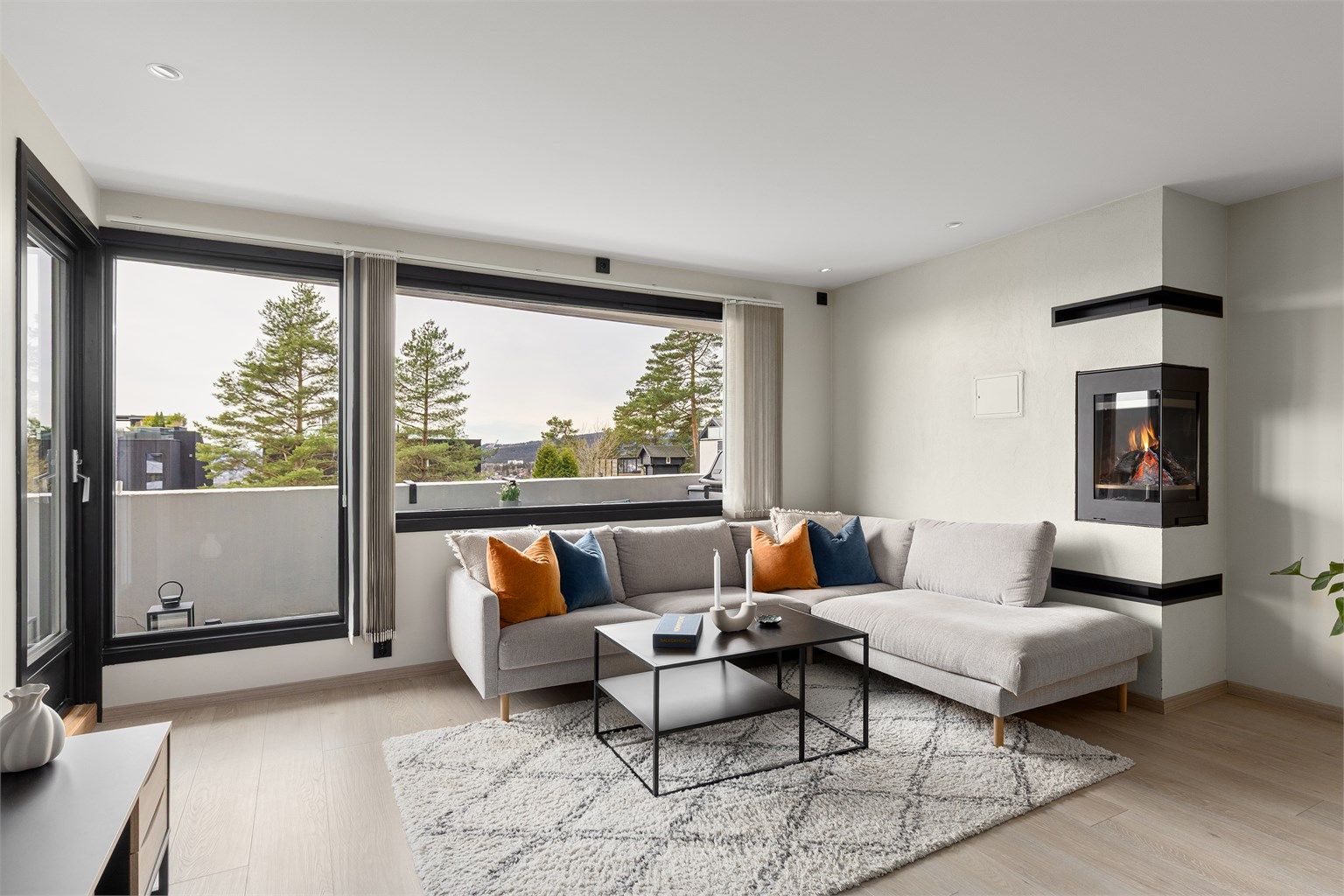 Stuen har god plass til stor sofagruppe. Den moderne peisinnsatsen er både praktisk og et blikkfang