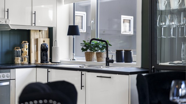 Kjøkkenet har fine detaljer som matchende farger på servant og håndtak i stil med benkeplaten.