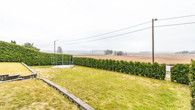 Hagen er pent innrammet av hekk og en ypperlig tumleplass for barna.