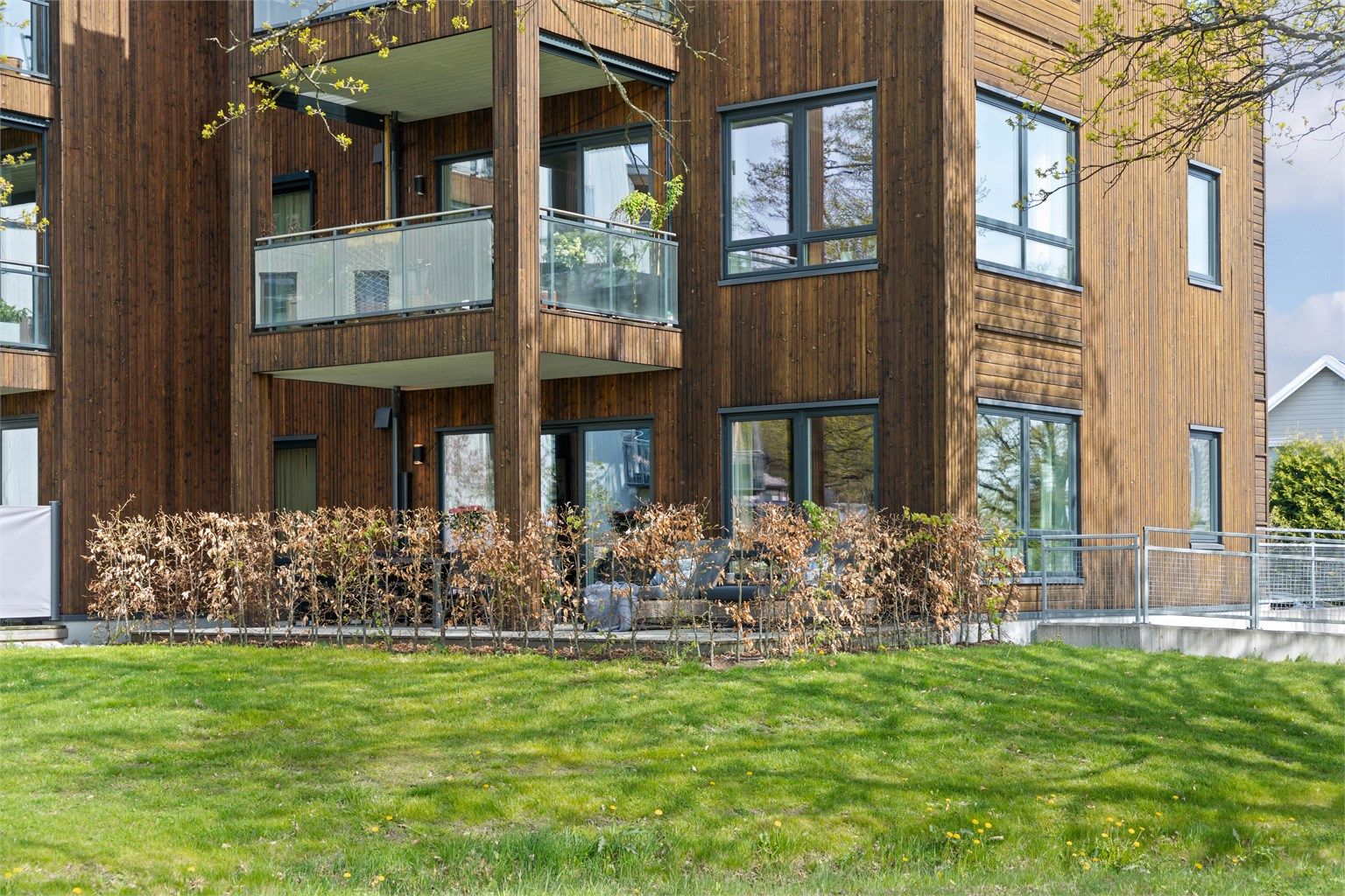 Terrassen har dekke i tre, og det er montert både utestikk og moderne utebelysning på husveggen.