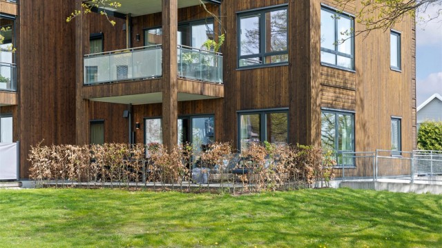 Terrassen har dekke i tre, og det er montert både utestikk og moderne utebelysning på husveggen.