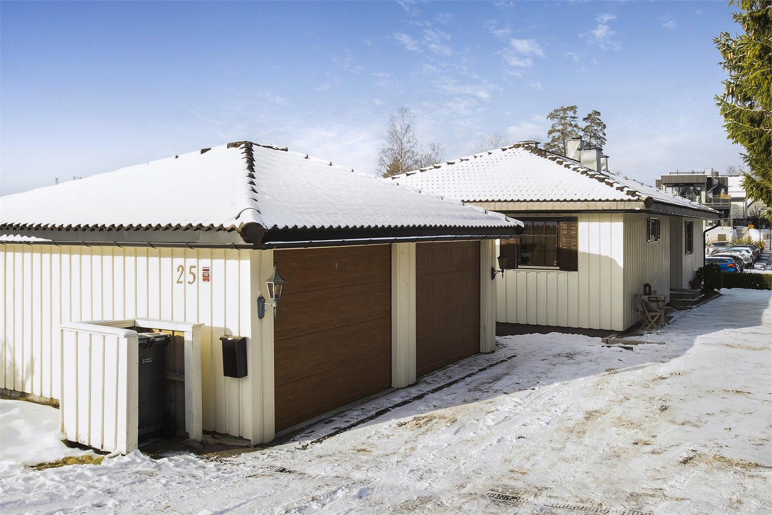 Dobbelgarasje og flere biloppstillingsplasser utenfor. 