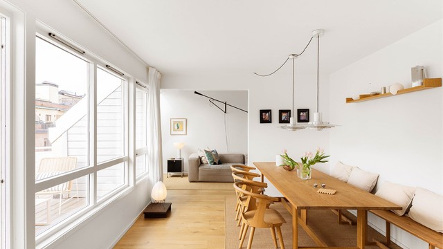 Spisestuen bærer det samme materialbevisste uttrykket som resten av boligen: lys eikeparkett, elektrisk gulvvarme og et langbord som får stå fritt i rommets fulle lengde.