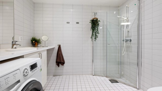 Badet har flislagt gulv med gulvvarme og flislagte vegger. Himlingsflate utført i malt glatt flate med downlights