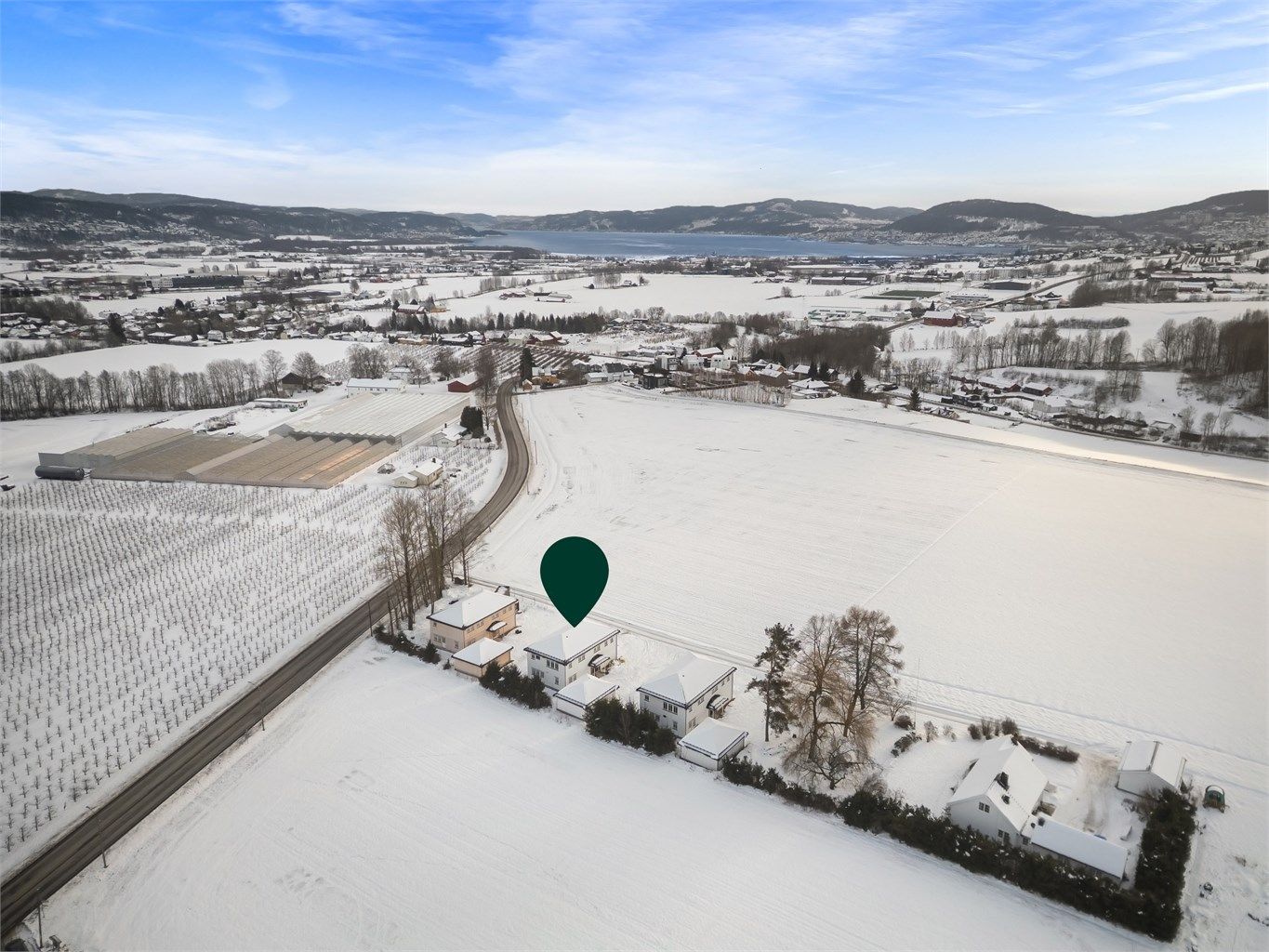 Eiendommen ligger i et åpent og landlig landskap. 
Foto: Ole Thorgeir Solheim Thoresen