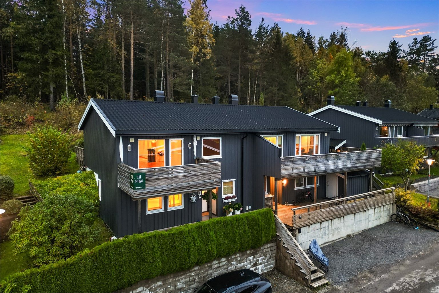 To parkeringsplasser ved inngangspartiet med mulighet for å etablere lader til el-bil samt garasjeplass i felles rekke.