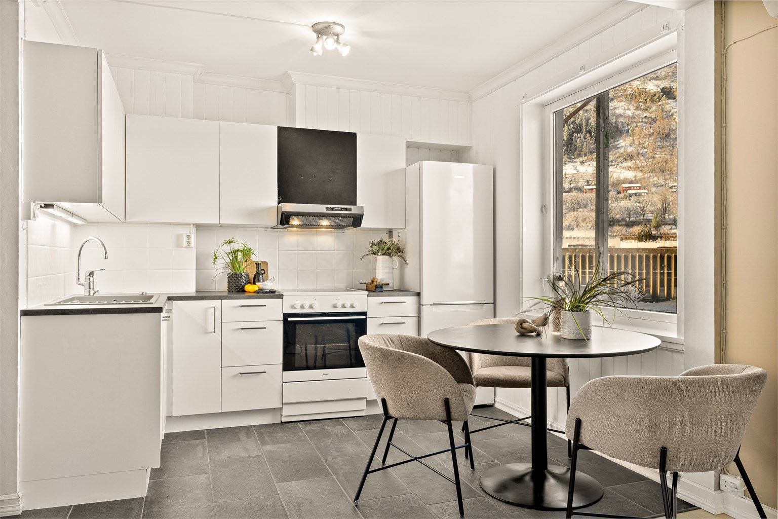 Lyst og praktisk kjøkken med plass til å spisebord.