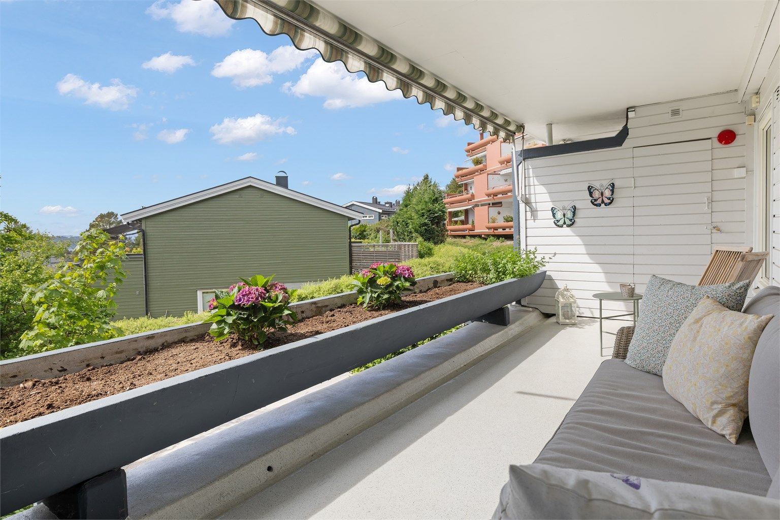 Romslig vestvendt terrasse med utebod og direkte adkomst til felles hage og gangstier.