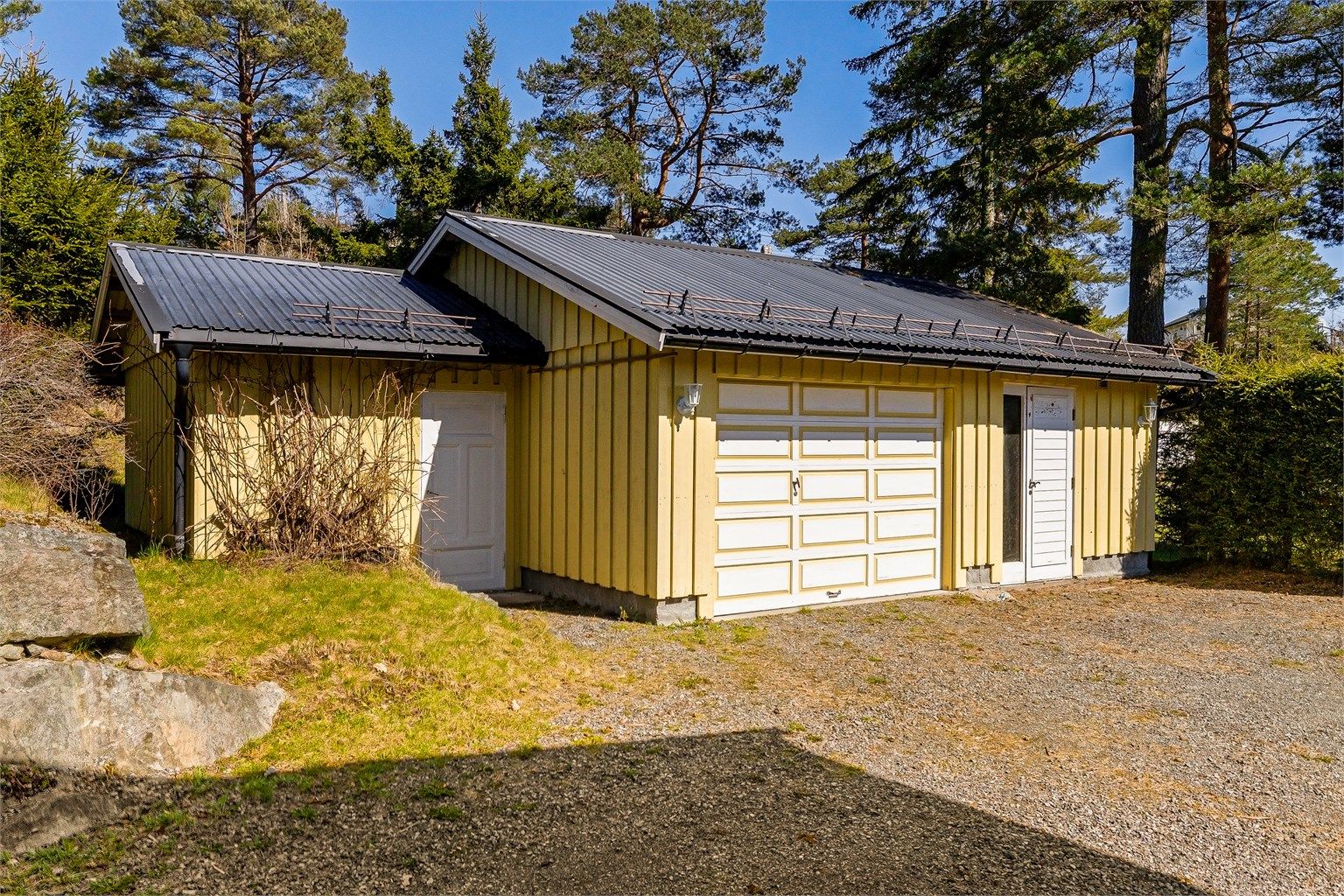 Garasje med el-bil lader og tilliggende boder.