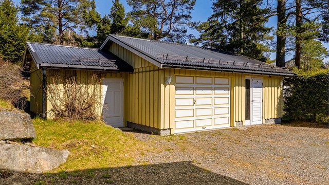 Garasje med el-bil lader og tilliggende boder.