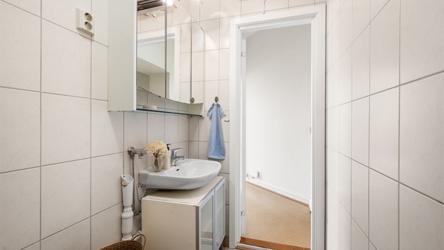 Servantinnredning, opplegg for vaskemaskin og praktiske løsninger gjør badet funksjonelt i hverdagen.