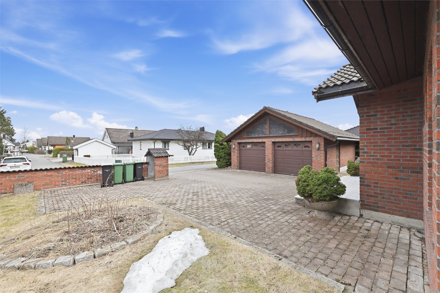 Fasade - Med eiendommen medfølger det en større dobbelt garasje. I tillegg er det god plass til flere biloppstillingsplasser på gårdsplass,