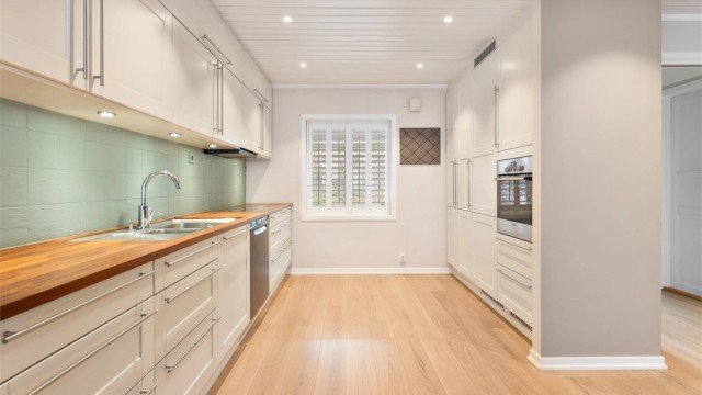 Benkeplaten i heltre med underlimt vask komplementeres av hvitevarer fra blant annet Bosch og Siemens.